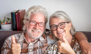 portrait-of-smiling-senior-couple-sitting-at-home-2023-11-27-05-29-10-utc-scaled